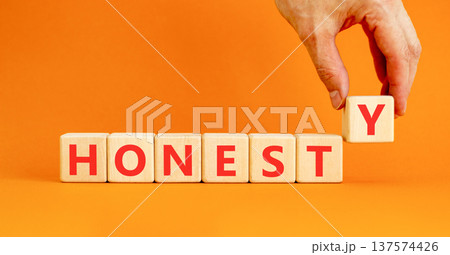 Honesty word symbol. Concept word Honesty on beautiful wooden blocks. Beautiful orange background. Businessman's hand. Business honesty concept. Copy space. Honesty word symbol. Concept word Honesty on beautiful wooden blocks. Beautiful orange background. Businessman's hand. Business honesty concept. Copy space. 137574426