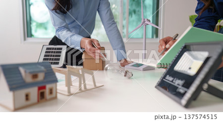 Sustainability and ESG. Professionals discussing renewable energy solutions with models. 137574515