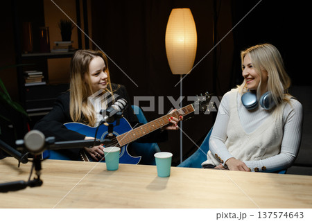 Musicians playing acoustic guitar and recording music in home studio Musicians playing acoustic guitar and recording music in home studio 137574643