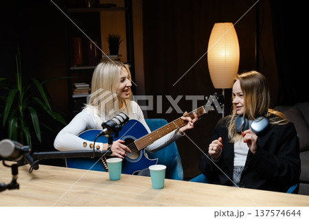 Two Female Musicians Playing Acoustic Guitar and Recording Podcast Two Female Musicians Playing Acoustic Guitar and Recording Podcast 137574644