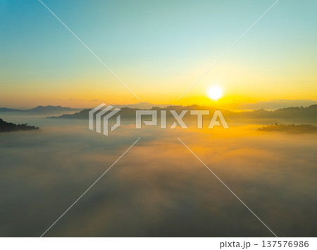Aerial view of flowing fog waves on mountain tropical rainforest,Bird eye view image over the clouds Amazing nature background with clouds and mountain peaks in Thailand Aerial view of flowing fog waves on mountain tropical rainforest,Bird eye view image over the clouds Amazing nature background with clouds and mountain peaks in Thailand 137576986