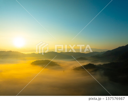 Aerial view of flowing fog waves on mountain tropical rainforest,Bird eye view image over the clouds Amazing nature background with clouds and mountain peaks in Thailand Aerial view of flowing fog waves on mountain tropical rainforest,Bird eye view image over the clouds Amazing nature background with clouds and mountain peaks in Thailand 137576987