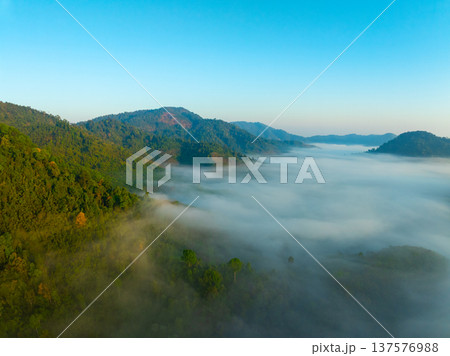 Aerial view of flowing fog waves on mountain tropical rainforest,Bird eye view image over the clouds Amazing nature background with clouds and mountain peaks in Thailand Aerial view of flowing fog waves on mountain tropical rainforest,Bird eye view image over the clouds Amazing nature background with clouds and mountain peaks in Thailand 137576988