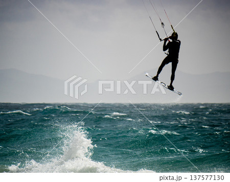 Kite surfer riding waves. Kiteboarding sport. 137577130