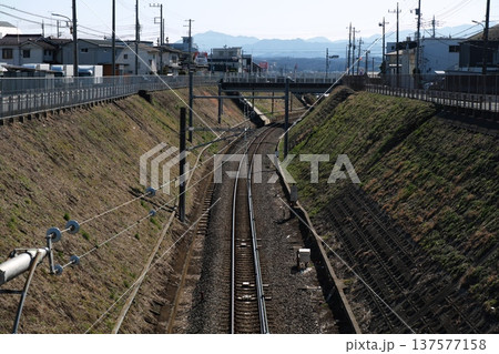 住宅街を抜ける線路と遠くに見える山々 住宅街を抜ける線路と遠くに見える山々 137577158