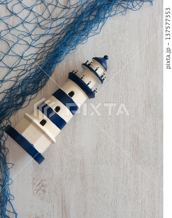 Toy lighthouses nautical blue decorative mesh on a wooden background 137577353