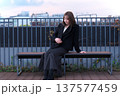 都会のテラスで佇む女性と阪急電鉄の線路。大阪の都市インフラと冬のライフスタイルが交差する風景。 137577459