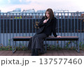 都会のテラスで佇む女性と阪急電鉄の線路。大阪の都市インフラと冬のライフスタイルが交差する風景。 137577460