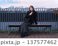 都会のテラスで佇む女性と阪急電鉄の線路。大阪の都市インフラと冬のライフスタイルが交差する風景。 137577462