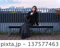 都会のテラスで佇む女性と阪急電鉄の線路。大阪の都市インフラと冬のライフスタイルが交差する風景。 137577463