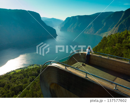 Tourist enjoying fjord view on Stegastein viewpoint Norway 137577602