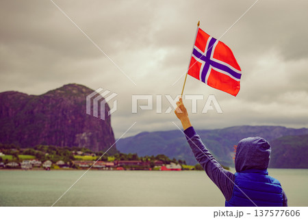 Tourist with norwegian flag on fjord 137577606
