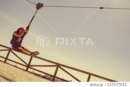Adult woman having fun on zipline Adult woman having fun on zipline 137577610