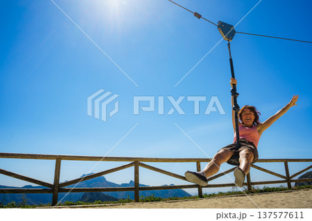 Adult woman having fun on zipline 137577611