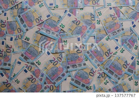 Dense texture of 20 Euro banknotes in a dynamic arrangement. Detailed macro shot of blue European currency featuring holograms and watermarks. Financial abundance concept 137577767