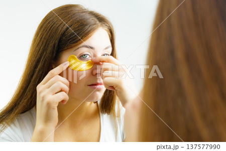 Woman with gold patches under eyes Woman with gold patches under eyes 137577990