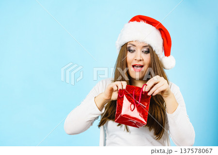 Christmas Woman looks into red gift bag Christmas Woman looks into red gift bag 137578067