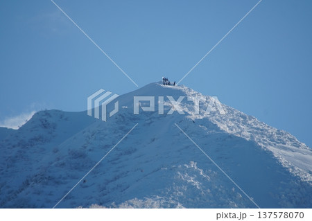 雪山に登頂した登山者達 137578070