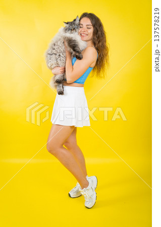 Happy young woman embracing fluffy cat with love Happy young woman embracing fluffy cat with love 137578219