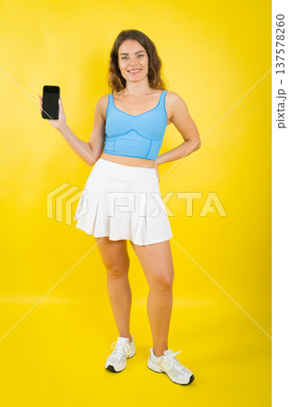Smiling woman holding smartphone with blank screen for app 137578260