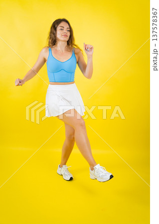 Woman dancing feeling happy and energetic on yellow background 137578367