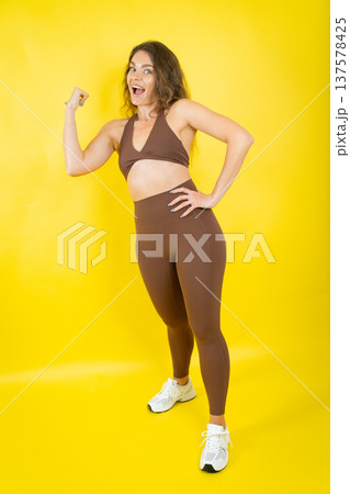 Confident woman flexing bicep showing strength and fitness Confident woman flexing bicep showing strength and fitness 137578425