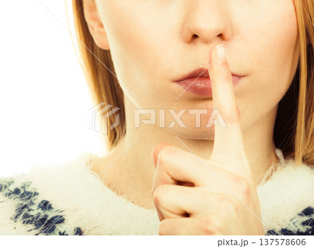 Young blonde woman making silence gesture Young blonde woman making silence gesture 137578606