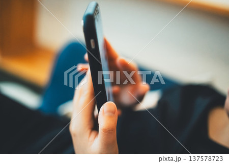 スマートフォンを持つ女性の手元 スマートフォンを持つ女性の手元 137578723
