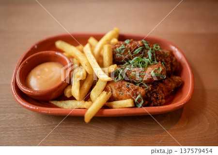 Crispy chicken wings and golden fries served with a creamy dipping sauce Crispy chicken wings and golden fries served with a creamy dipping sauce 137579454