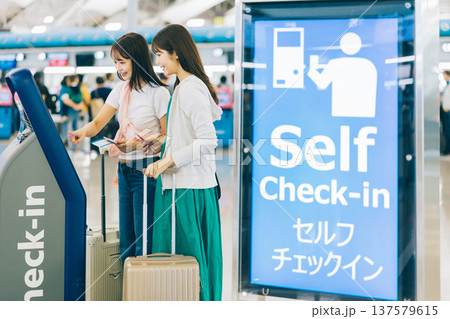 空港でセルフチェックインをする女性二人組　「撮影協力：関西国際空港（KIX）」 137579615
