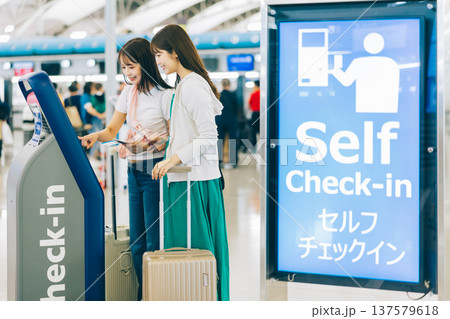 空港でセルフチェックインをする女性二人組 「撮影協力:関西国際空港(KIX)」 空港でセルフチェックインをする女性二人組 「撮影協力:関西国際空港(KIX)」 137579618