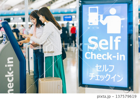 空港でセルフチェックインをする女性二人組　「撮影協力：関西国際空港（KIX）」 137579619