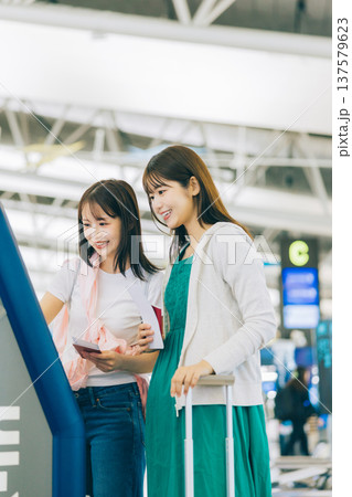 空港でセルフチェックインをする女性二人組 「撮影協力:関西国際空港(KIX)」 空港でセルフチェックインをする女性二人組 「撮影協力:関西国際空港(KIX)」 137579623