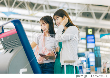 空港でセルフチェックインをする女性二人組 「撮影協力:関西国際空港(KIX)」 空港でセルフチェックインをする女性二人組 「撮影協力:関西国際空港(KIX)」 137579624
