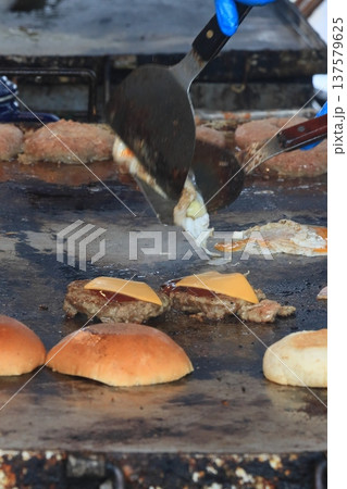 鉄板で焼き上げられるハンバーガー 137579625