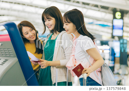 空港でセルフチェックインをする女性三人組　「撮影協力：関西国際空港（KIX）」 137579848