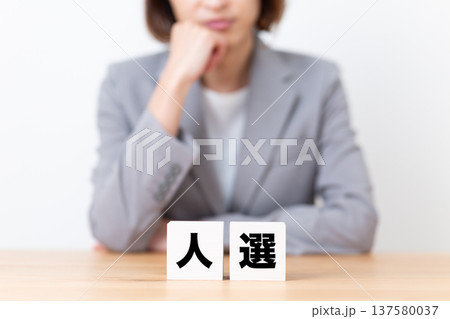 人選のブロックと悩むスーツ姿のミドル女性 137580037
