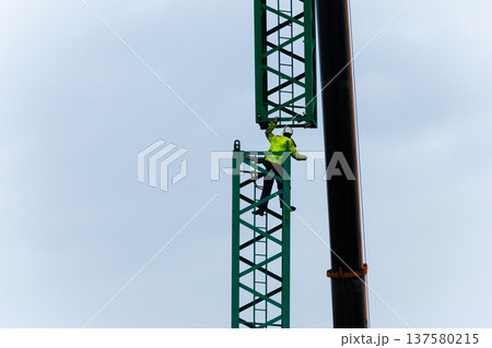 Construction worker on crane tower performing high risk job task Construction worker on crane tower performing high risk job task 137580215