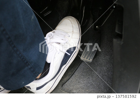 ブレーキペダルを踏む足 137581592