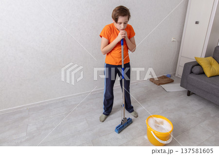Young person cleaning a room while preparing to mop the floor Young person cleaning a room while preparing to mop the floor 137581605