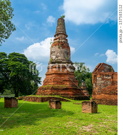 Ancient stupa towers in Ayutthaya historical park, Thailand. Ruins of former Siam capital under blue sky on sunny day. Famous travel destination with cultural heritage and Buddhist history. Ancient stupa towers in Ayutthaya historical park, Thailand. Ruins of former Siam capital under blue sky on sunny day. Famous travel destination with cultural heritage and Buddhist history. 137583112