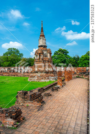 Ancient stupa towers in Ayutthaya historical park, Thailand. Ruins of former Siam capital under blue sky on sunny day. Famous travel destination with cultural heritage and Buddhist history. Ancient stupa towers in Ayutthaya historical park, Thailand. Ruins of former Siam capital under blue sky on sunny day. Famous travel destination with cultural heritage and Buddhist history. 137583123