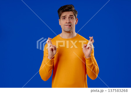 Handsome Man Crossing Fingers. Praying With Hopeful Expression, Silently Prays Handsome Man Crossing Fingers. Praying With Hopeful Expression, Silently Prays 137583268