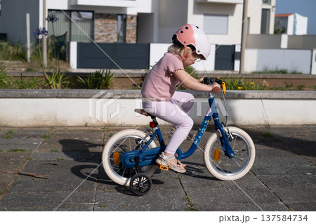 Little Girl Learning to Ride a Bicycle Little Girl Learning to Ride a Bicycle 137584734