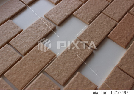 Missing areas on surface covered in even rows of wall tiles with brickwork imitation Missing areas on surface covered in even rows of wall tiles with brickwork imitation 137584973
