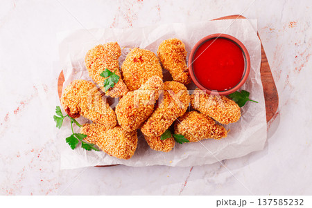 fried chicken legs in breadcrumbs, on a wooden chopping board, with red sauce, no people, fried chicken legs in breadcrumbs, on a wooden chopping board, with red sauce, no people, 137585232
