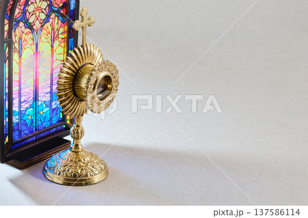 Monstrance for eucharistic adoration with stained glass background 137586114