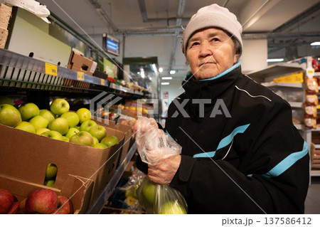 Senior woman shopping for green apples 137586412
