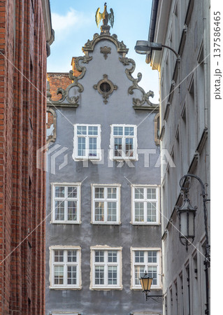 Gdansk, a city on the Baltic coast of northern Poland, Europe. Detailed facade with intricate architecture featuring white-framed windows and ornate embellishments, captured between buildings. Gdansk, a city on the Baltic coast of northern Poland, Europe. Detailed facade with intricate architecture featuring white-framed windows and ornate embellishments, captured between buildings. 137586465
