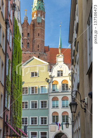 Gdansk, a city on the Baltic coast of northern Poland, Europe. European architecture presents a vintage charm with ivy-covered facades and a prominent church steeple reaching into the bright blue sky. Gdansk, a city on the Baltic coast of northern Poland, Europe. European architecture presents a vintage charm with ivy-covered facades and a prominent church steeple reaching into the bright blue sky. 137586473
